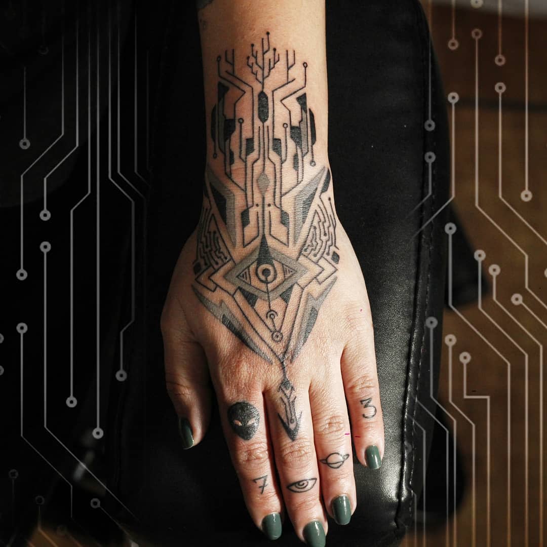 Detailed cyberpunk tattoo on hand featuring symmetrical geometric and circuit-inspired designs